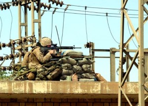 From a rooftop position, Marines with G Company, 2nd Battalion, 1st Marine Regiment, aim at a building from which shots had been fired in Fallujah, Iraq, April 6, 2004. U.S. Marine Corps photo by Lance Cpl. Nathan Alan Heusdens